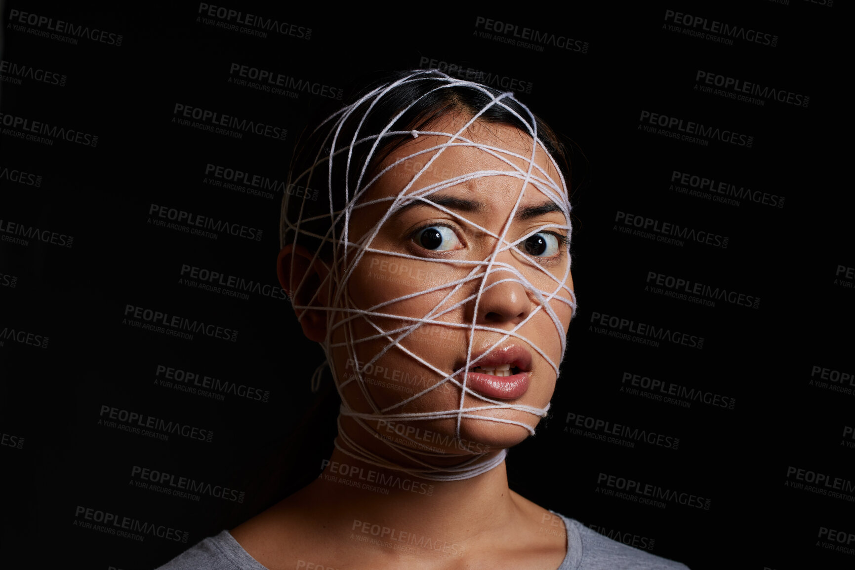 Buy stock photo Woman, rope and scared face for crime, kidnapping and danger with hostage, bondage and mental health. Female person, portrait and trapped in studio on black background for fear, violence and anxiety