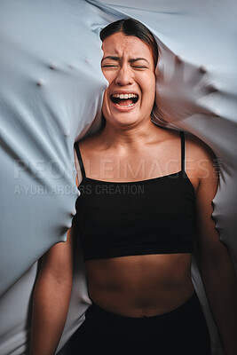 Buy stock photo Shot of a young woman experiencing mental illness against a spooky background