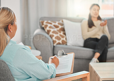 Buy stock photo Shot of a psychologist making notes during a consultation