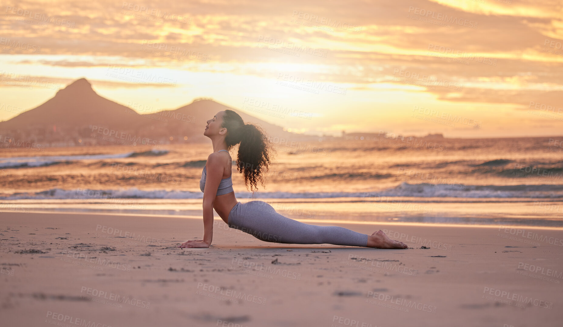 Buy stock photo Woman, fitness and yoga with sunset on beach for stretching, workout or outdoor exercise in nature. Young, female person or yogi in cobra pose for zen, awareness or health and wellness on ocean coast