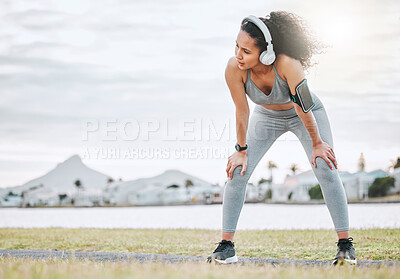 Buy stock photo Fitness, woman and tired athlete with headphones outdoor for exercise break, breathing and intense performance. Runner, person and exhausted of marathon practice with workout run, fatigue and space