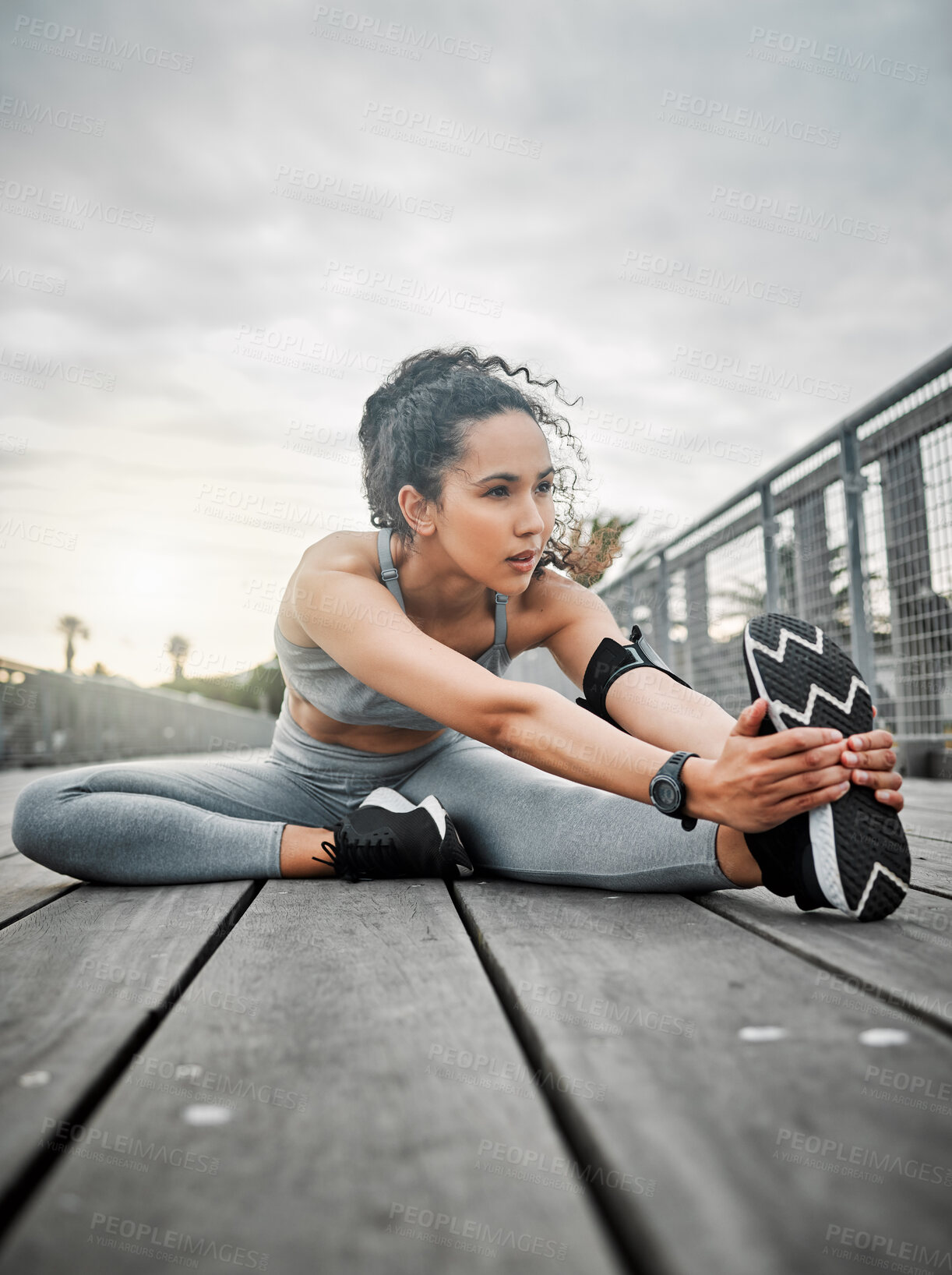 Buy stock photo Woman, legs and stretching outdoor for running, fitness and cardio exercise in morning with low angle. Female person, muscle and warm up on bridge for health, training and workout with vision or idea