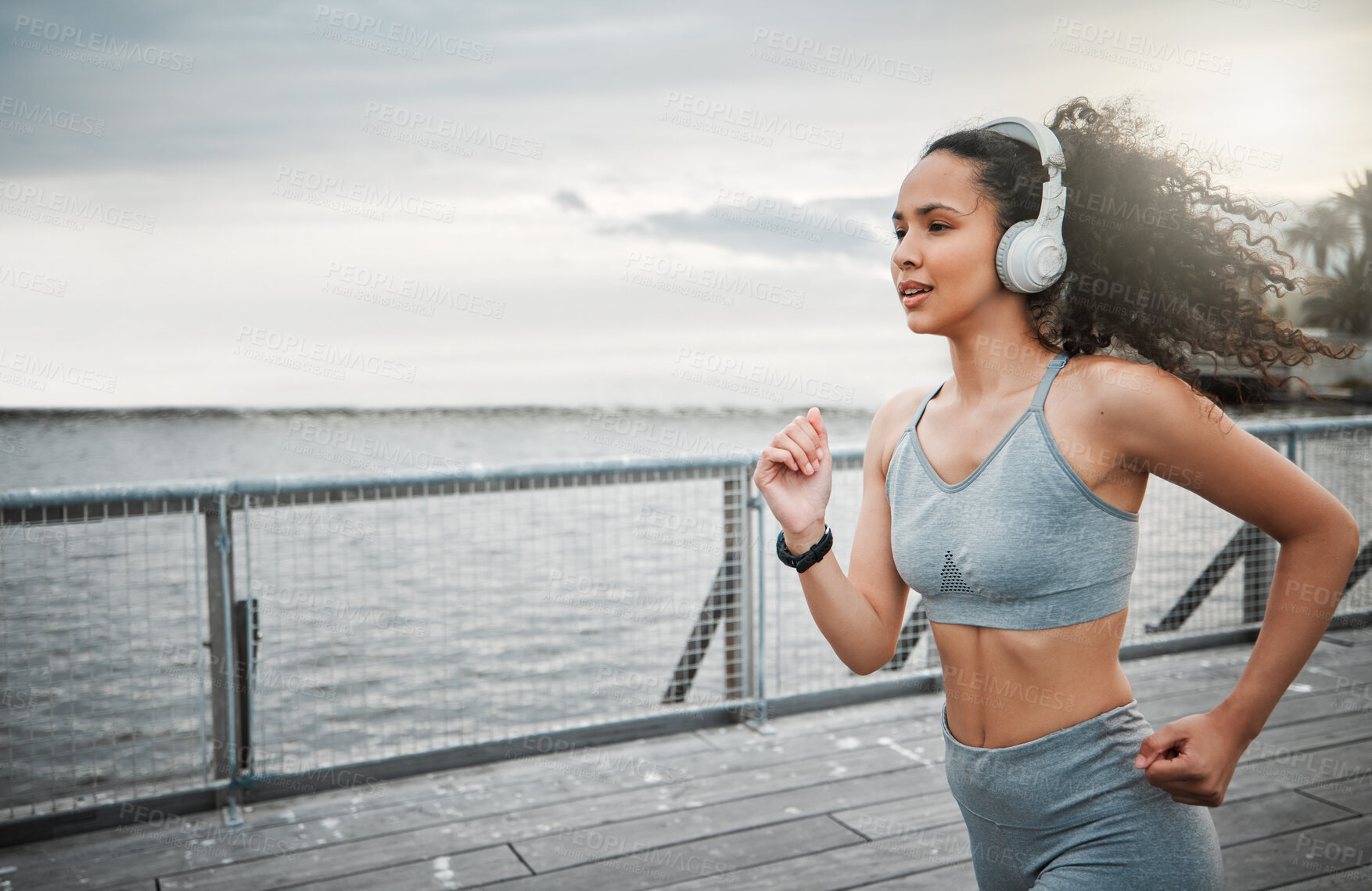 Buy stock photo Woman, music and running outdoor for fitness, sports and cardio exercise in morning with headphones. Female person, listening and jog on bridge for health, training and workout with radio or playlist