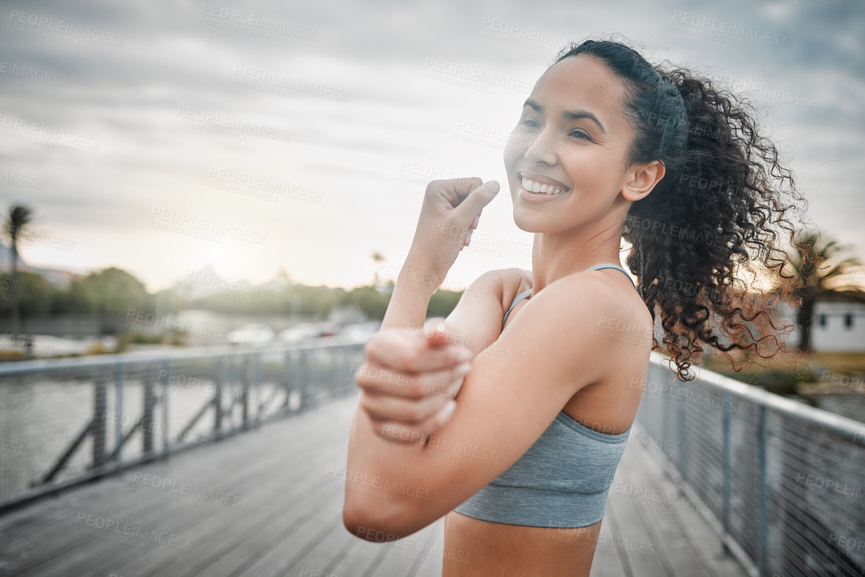 Buy stock photo Woman, happy and stretching arms for fitness, sport and muscle exercise in morning with lake outdoor. Female person, smile and warm up on bridge for health, training or workout with physical activity