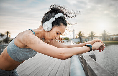 Buy stock photo Outdoor, woman and tired with headphones for fitness, hearing music or listening to workout playlist. Female person, runner and rest with breathing after running, wellness exercise or audio by bridge