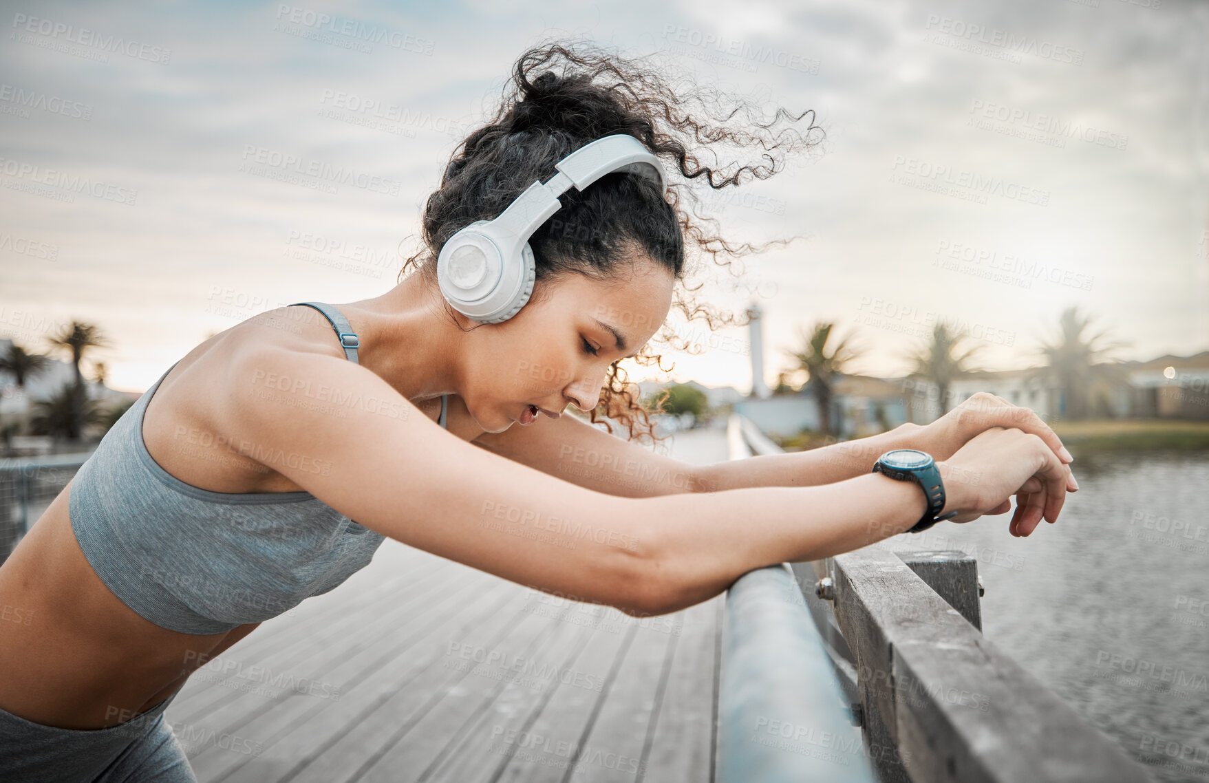 Buy stock photo Outdoor, woman and tired with headphones for fitness, hearing music or listening to workout playlist. Female person, runner and rest with breathing after running, wellness exercise or audio by bridge