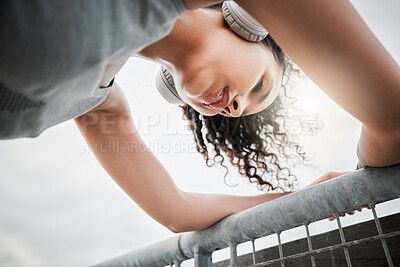 Buy stock photo Low angle, woman and tired with headphones for fitness, hearing music or listening to workout playlist. Female person, runner and rest with breathing after running, wellness exercise or audio outdoor