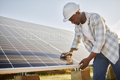 Buy stock photo Shot of a young man standing in front of solar panel on a farm