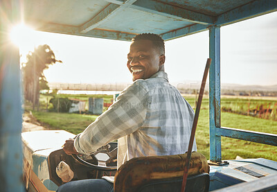 Buy stock photo Shot of a young farmer driving a tractor on a farm