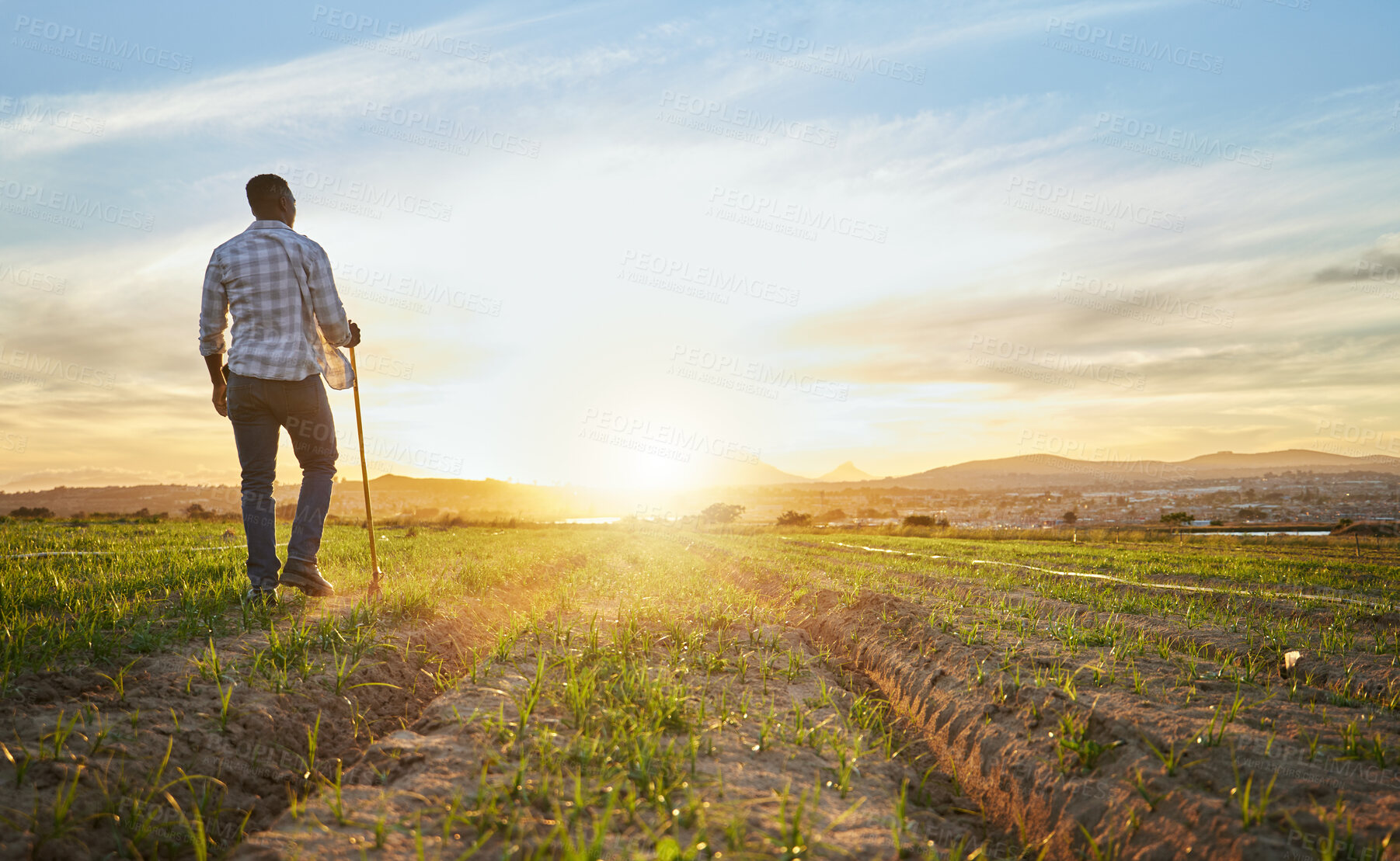 Buy stock photo Shot of a farmer standing on a field