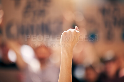 Buy stock photo Shot of a protestor with their fist in the air at a rally