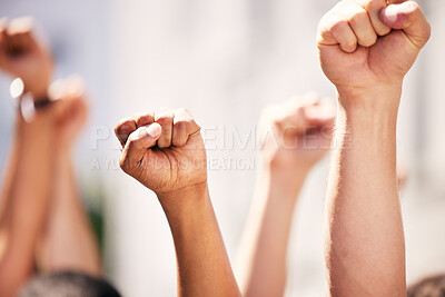 Buy stock photo Shot of a group of people with their fists raised at a protest
