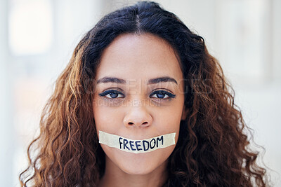 Buy stock photo Portrait of a young woman with tape on her mouth that has the word 