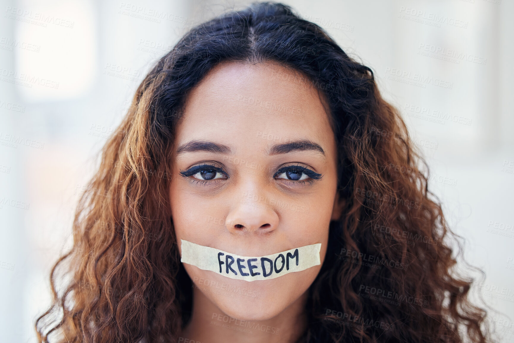Buy stock photo Portrait of a young woman with tape on her mouth that has the word 