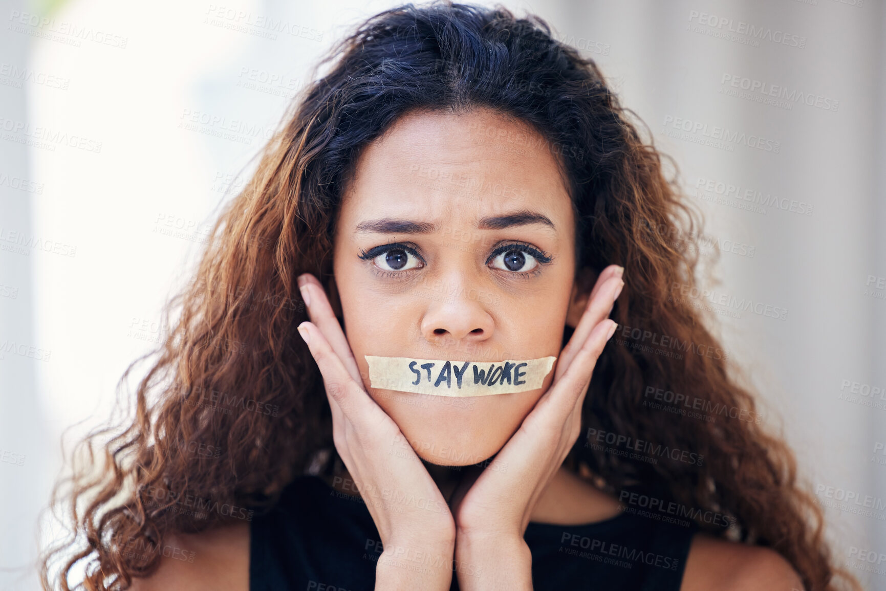 Buy stock photo Portrait of a young woman with tape on her mouth that has the words 