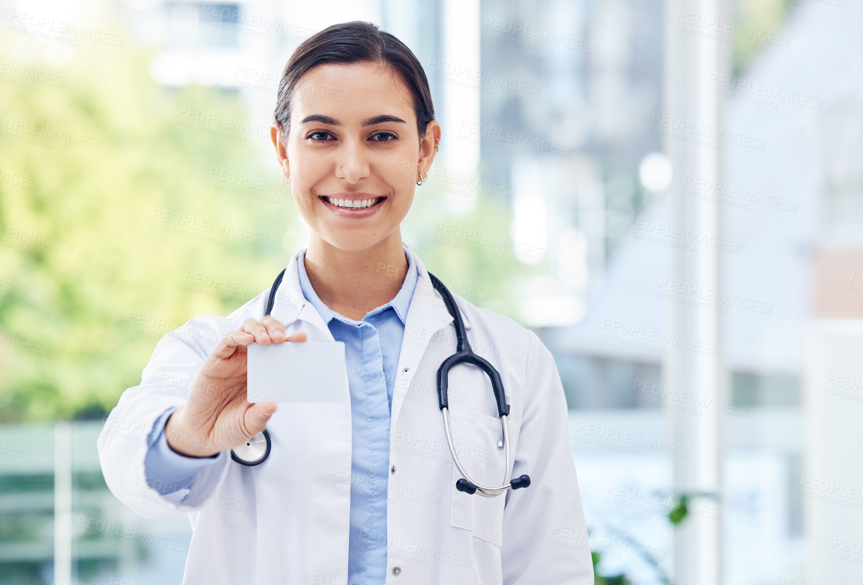 Buy stock photo Portrait of a young doctor holding a blank card in a hospital