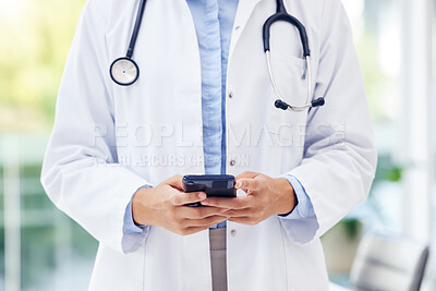 Buy stock photo Closeup shot of an unrecognisable doctor using a cellphone in a hospital
