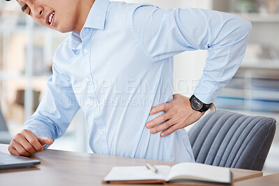 Buy stock photo Shot of a young businessman suffering from back pain at work