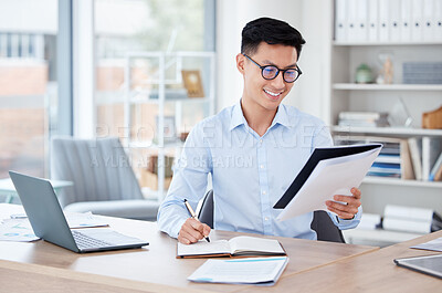 Buy stock photo Shot of a young businessman writing in a notebook at work