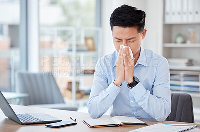 Buy stock photo Shot of a young businessman blowing his nose in an office at work
