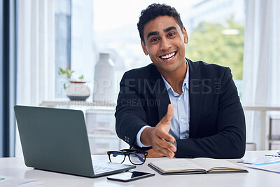 Buy stock photo Portrait of a young businessman extending a handshake while working in an office