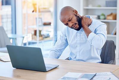 Buy stock photo Shot of a young businessman suffering from back pain in a modern office at work