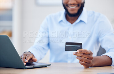 Buy stock photo Shot of a young businessman using a credit card and laptop at work