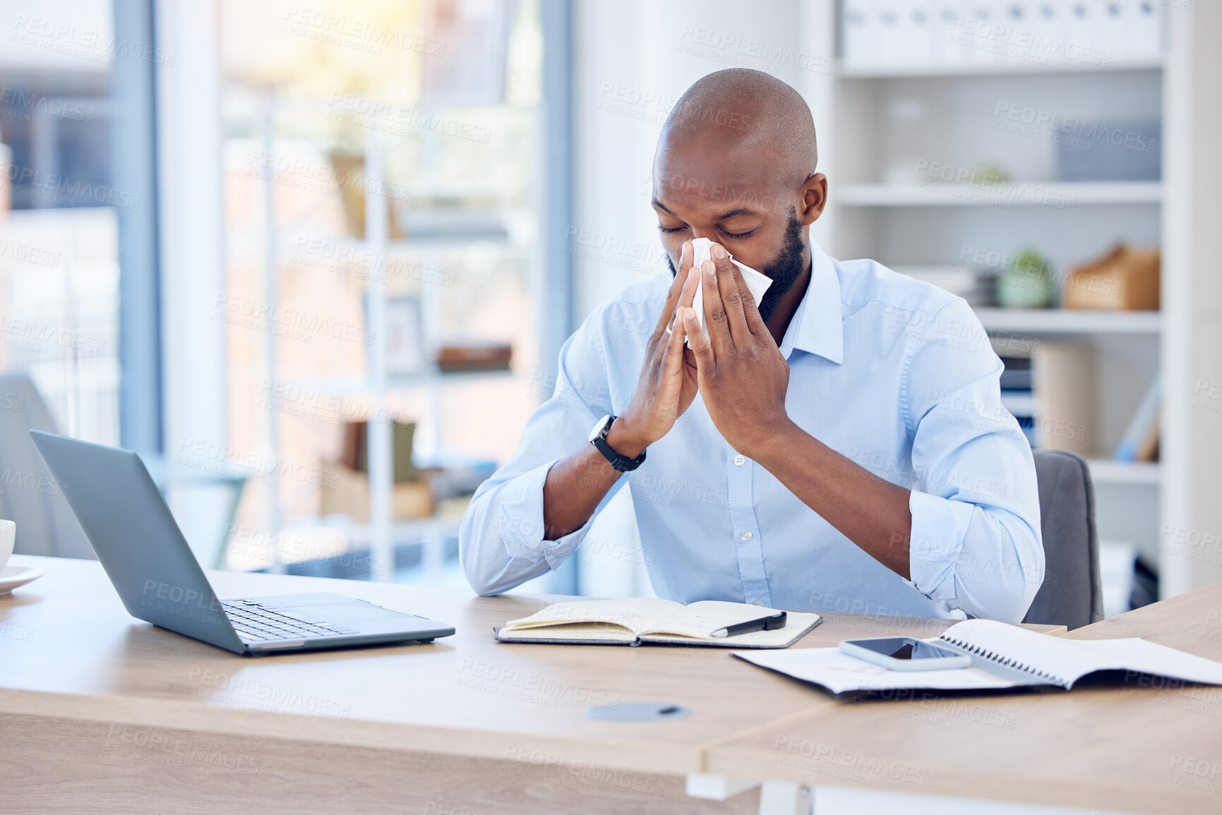 Buy stock photo Sick, business and black man blowing nose in office for allergies, virus or flu. Lawyer, laptop and male employee with tissue by desk with notebook for disease, infection or sneeze at law firm