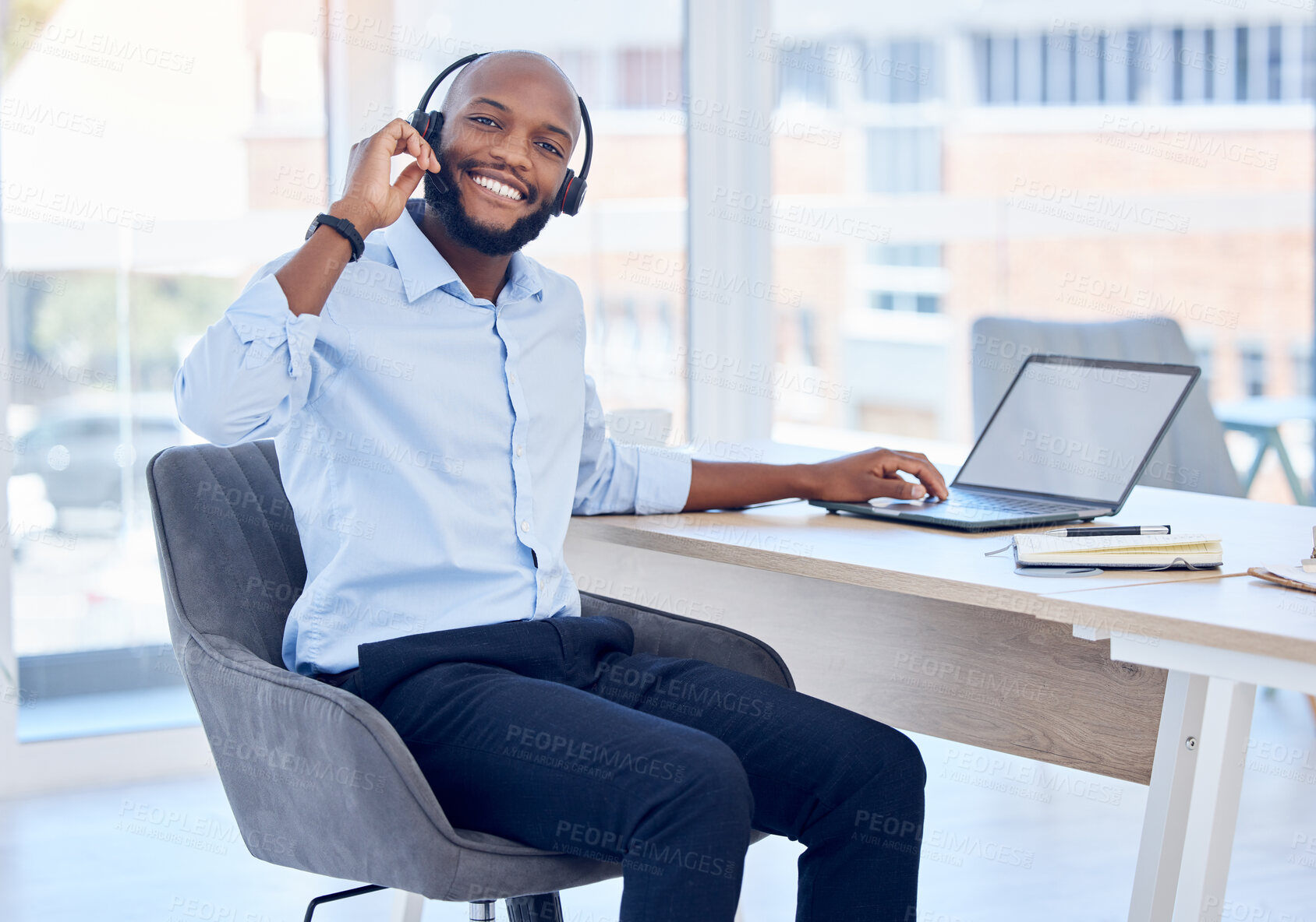 Buy stock photo Shot of a young male call center agent working in an office