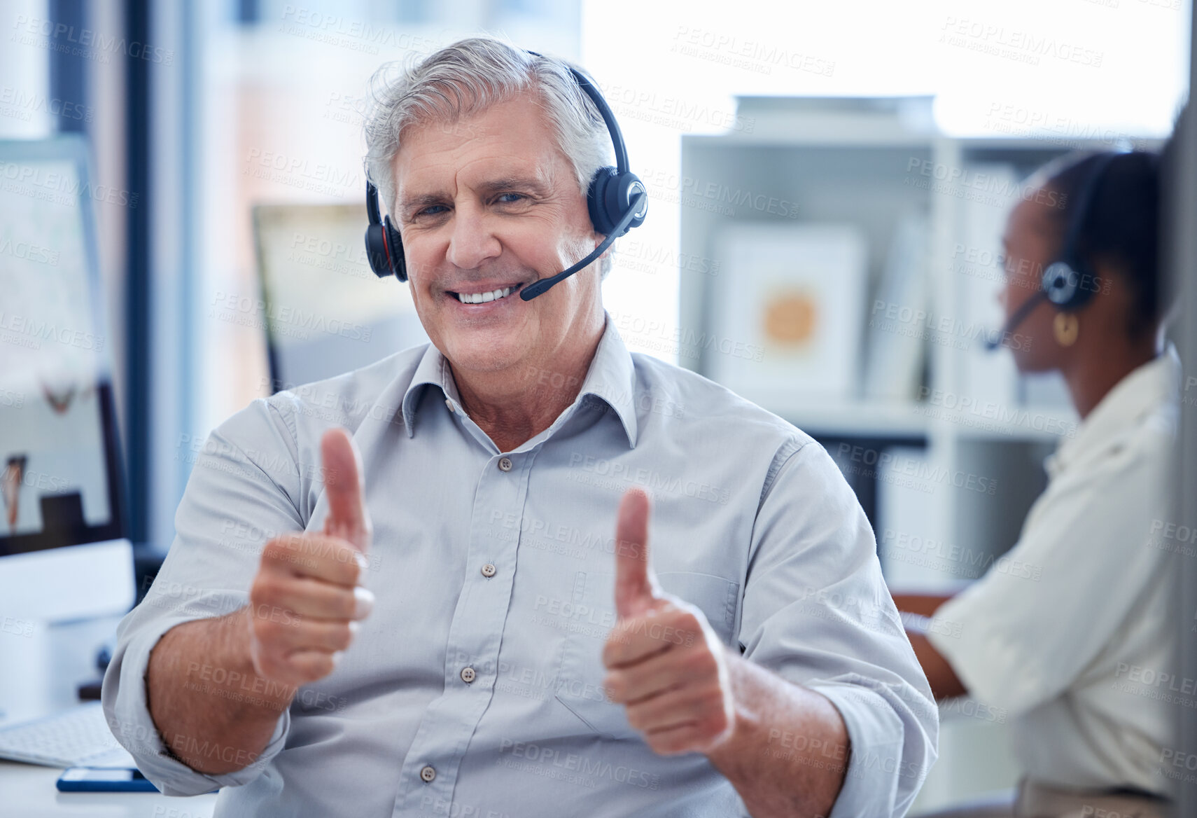 Buy stock photo Portrait of a mature call centre agent showing thumbs up in an office