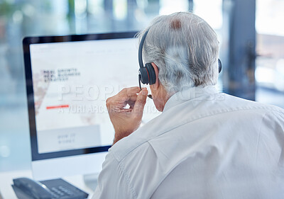 Buy stock photo Rearview shot of a mature call centre agent working on a computer in an office