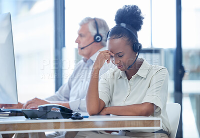 Buy stock photo Shot of a young call centre agent looking stressed out while working in an office