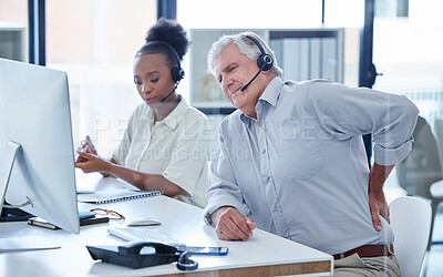 Buy stock photo Shot of a mature call centre agent experiencing lower back pain while working in an office