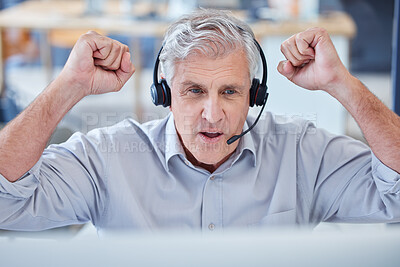 Buy stock photo Shot of a mature call centre agent cheering while working on a computer in an office