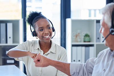 Buy stock photo Shot of a young call centre agent giving her colleague a fist bump in an office