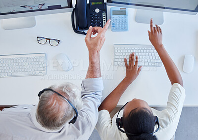 Buy stock photo High angle shot of two call centre agents working together on a computer in an office