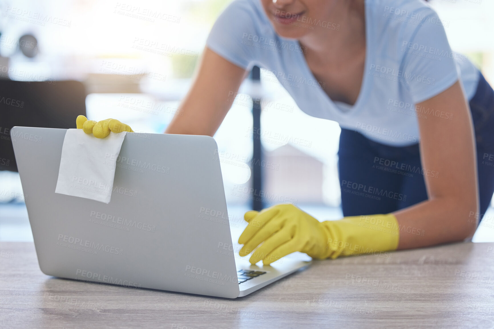Buy stock photo Shot of an unrecognizable woman carefully cleaning a laptop at home