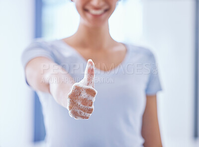 Buy stock photo Shot of an unrecognizable woman showing a soapy thumbs up while cleaning her apartment