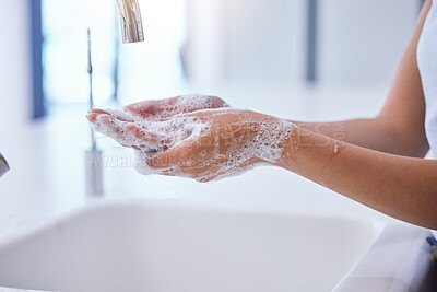 Buy stock photo Shot of an unrecognizable woman washing her hands at the kitchen sink