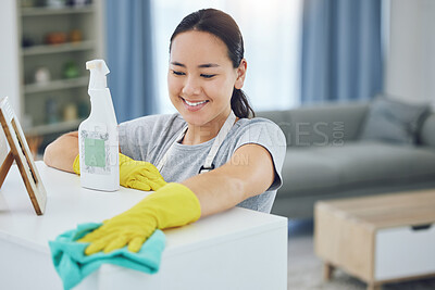 Buy stock photo Shot of a young woman wiping a table at home