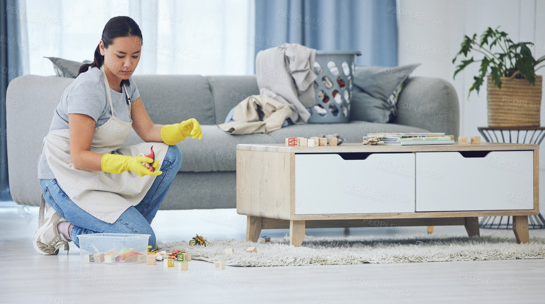 Buy stock photo Shot of a young woman cleaning at home