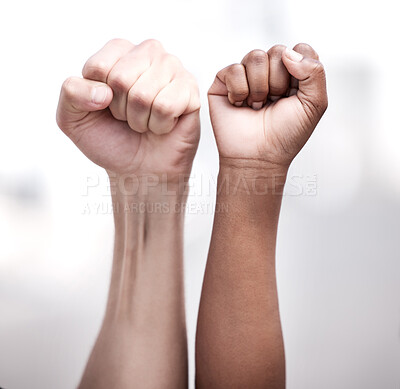 Buy stock photo Shot of two protestors with their fists raised during a rally