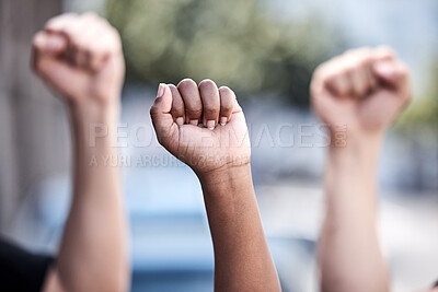 Buy stock photo Shot of a group of protestors with their hands raised in the air