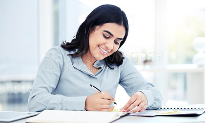 Buy stock photo Shot of a young businesswoman writing notes in an office