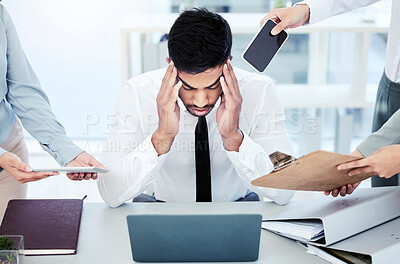 Buy stock photo Shot of a young businessman looking stressed out while working in a demanding office environment