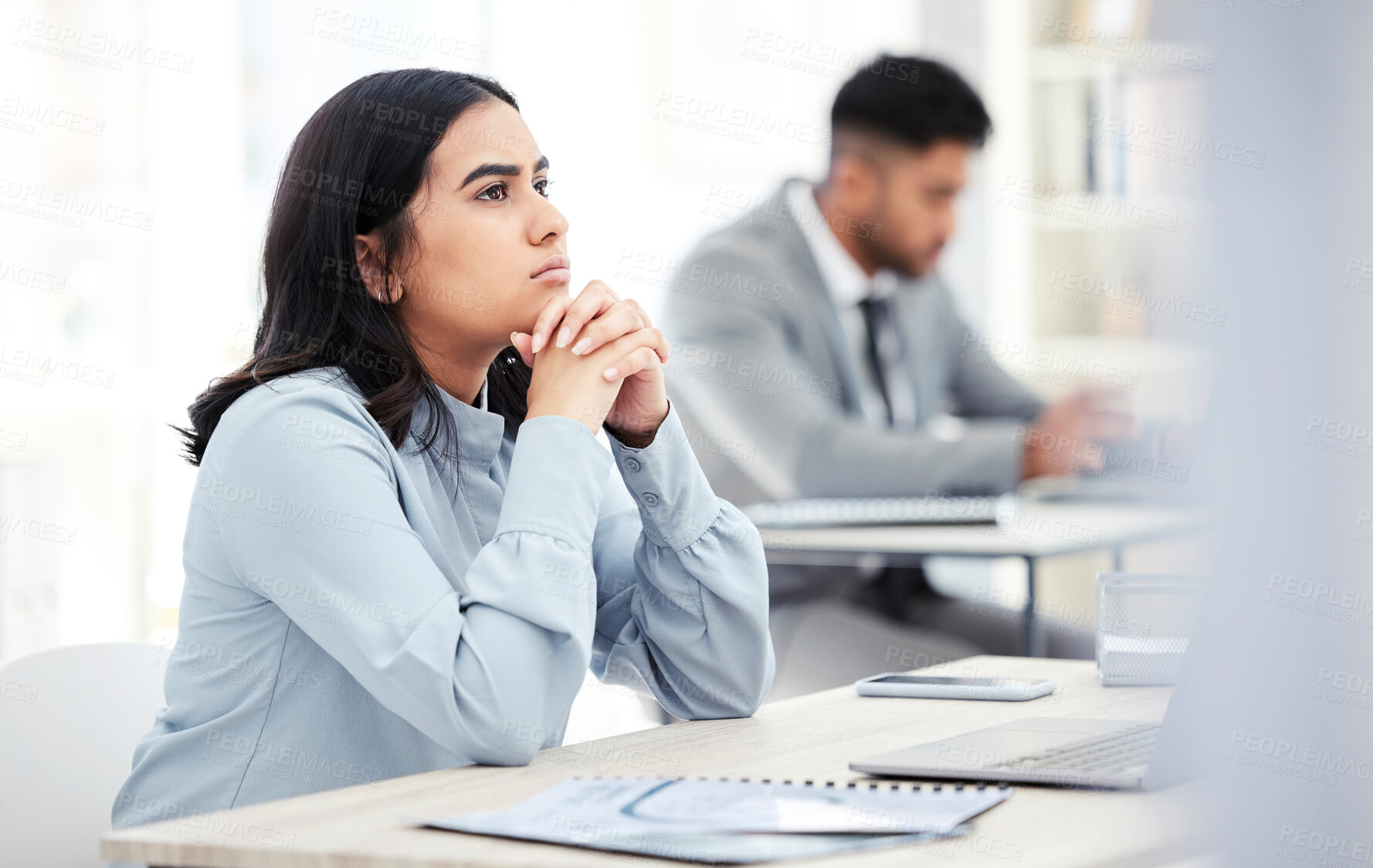 Buy stock photo Shot of a young businesswoman looking thoughtful while working on a laptop in an office