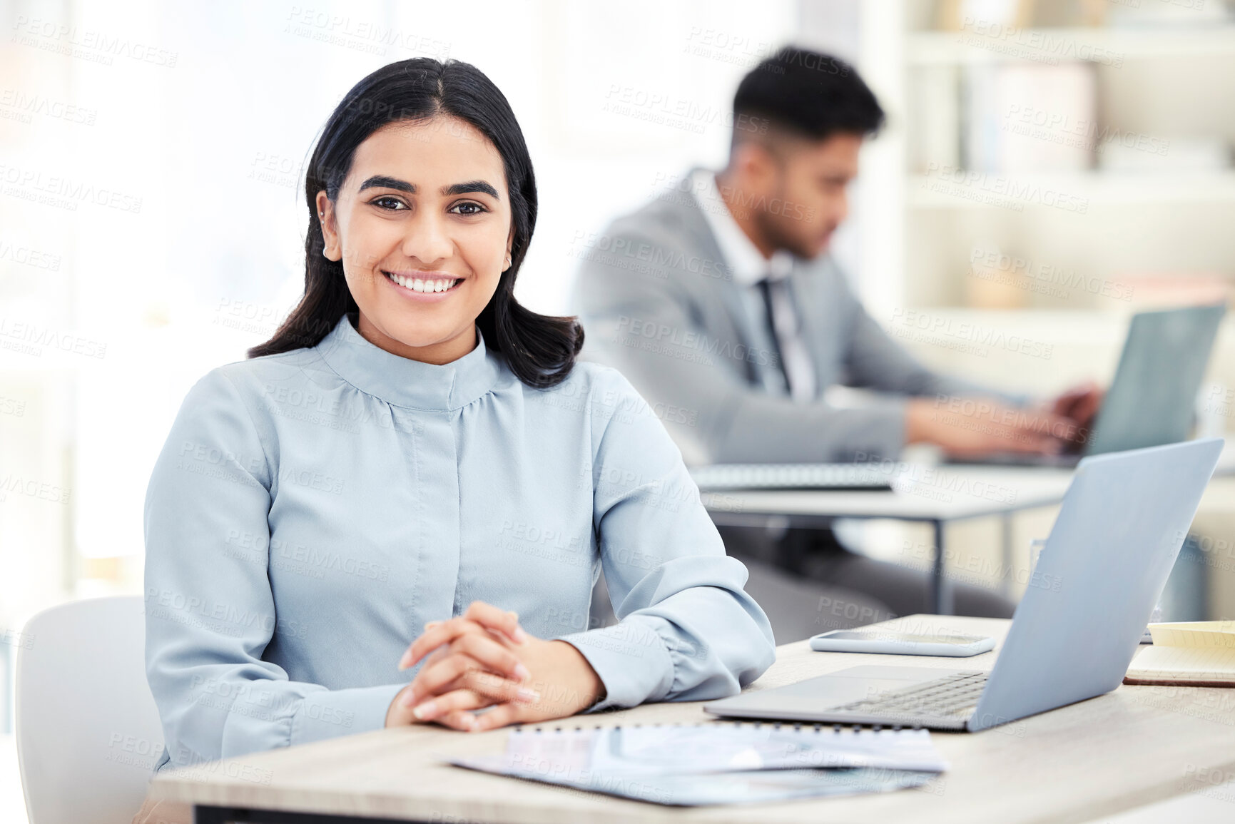 Buy stock photo Portrait of a confident young businesswoman working on a laptop in an office