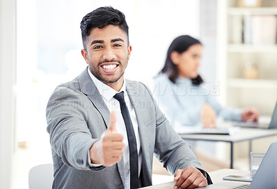 Buy stock photo Portrait of a young businessman showing thumbs up while working in an office