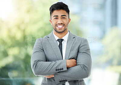 Buy stock photo Cropped portrait of a handsome young businessman standing with his arms folded in the office