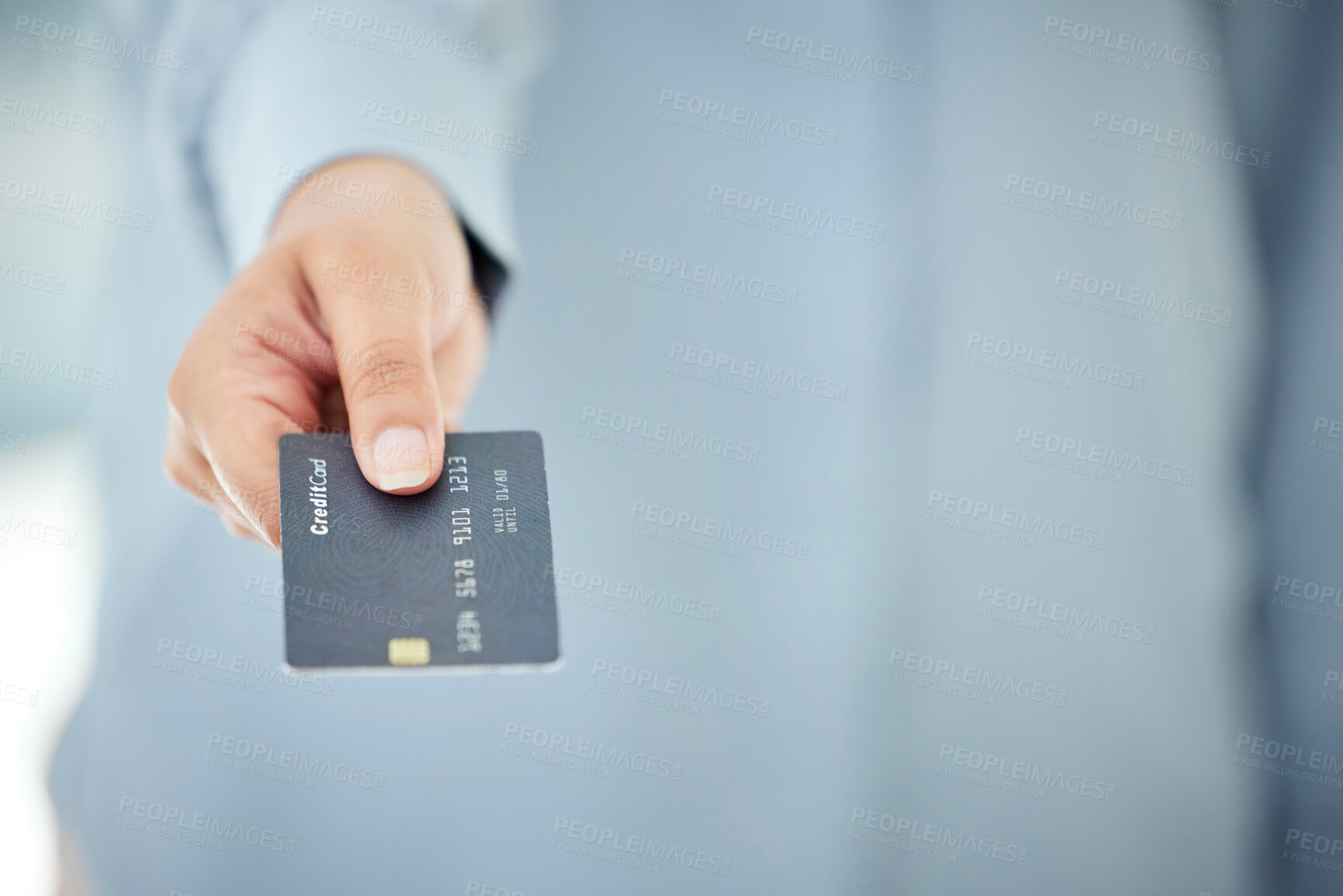 Buy stock photo Cropped shot of an unrecognizable businesswoman holding out her credit card while standing in the office